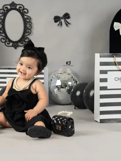 A chic and sophisticated Chanel-inspired theme for a stylish first birthday. The black and white palette with silver disco balls creates a very modern look.