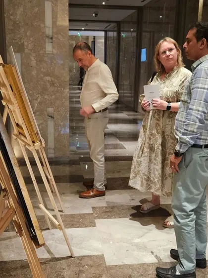 Guests at the 'Art Soirée' discussing the artworks displayed on easels.