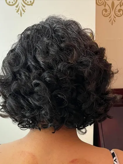 The back of Maya's curly bob, demonstrating the full, rounded shape that makes this style so flattering.