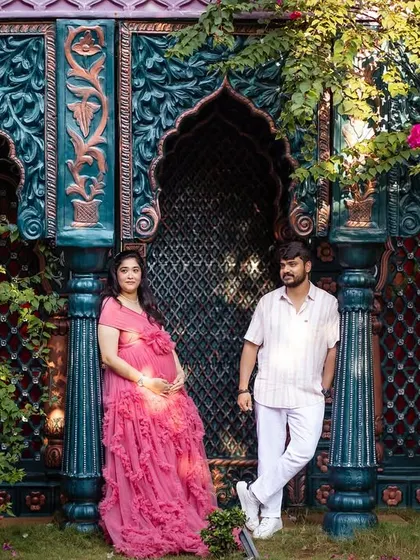 A regal pose against an ornate backdrop in our garden studio. The combination of the intricate set and the flowing pink gown creates a majestic and colorful portrait.