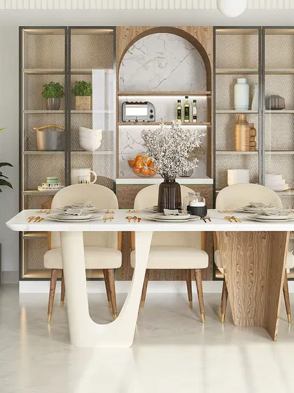 A frontal view of the unique dining table, showcasing its sculptural base. The crockery unit behind it features rattan-panelled doors, blending modern design with natural textures.