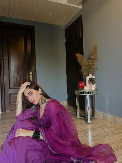 A more relaxed, seated pose in the purple anarkali, showing the beautiful drape of the fabric.