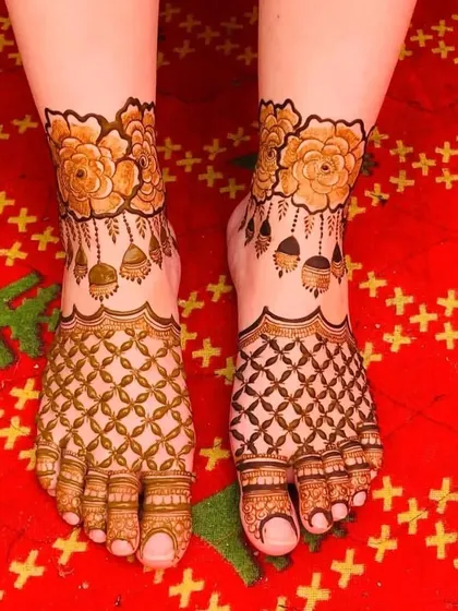 This foot design features a geometric jaal pattern on the lower part and a beautiful floral band with hanging jhumkas on the ankle.