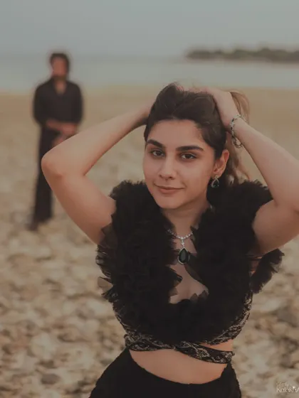 A beautiful portrait of the bride-to-be on the beach, with her partner softly focused in the background, creating a sense of depth and story.