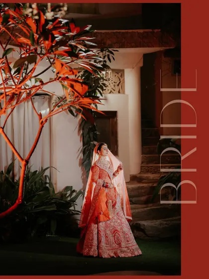 A dramatic and artistic portrait of the bride, illuminated by a single light source, highlighting the rich color of her lehenga and her serene expression.