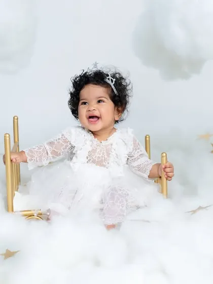 A joyful laugh from our little angel on her cloud bed. Her happiness is infectious in this beautiful, all-white themed portrait session.