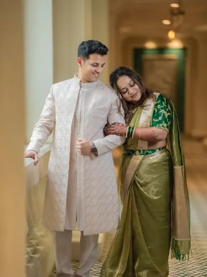 A quiet, tender moment between Shami and Udit in an elegant hotel corridor. The soft light and her gentle lean create a very romantic mood.