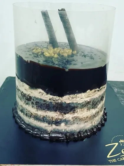 This is our interactive pull-me-up cake. When you lift the plastic collar, a rich layer of chocolate ganache cascades down the sides, creating a delicious waterfall effect over the layered cake.