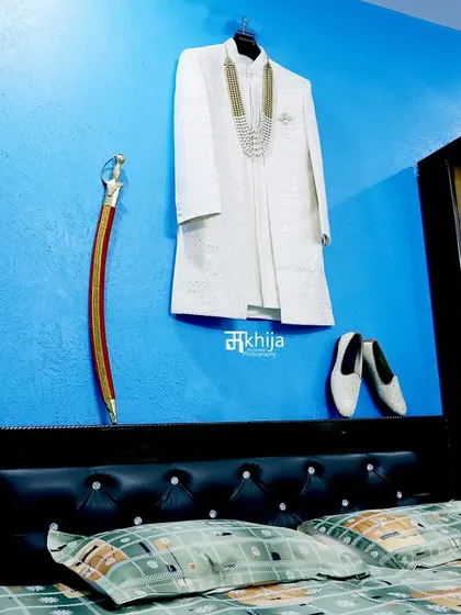 The groom's attire, ready and waiting. I often take detailed shots of the sherwani, shoes, and traditional accessories like the sword, as they are an important part of the wedding story.