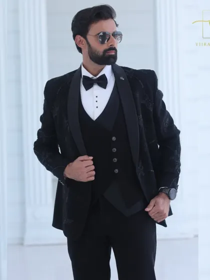 The three-piece construction of our black embroidered tuxedo is visible here. We can create suits with or without a waistcoat based on your style preference.