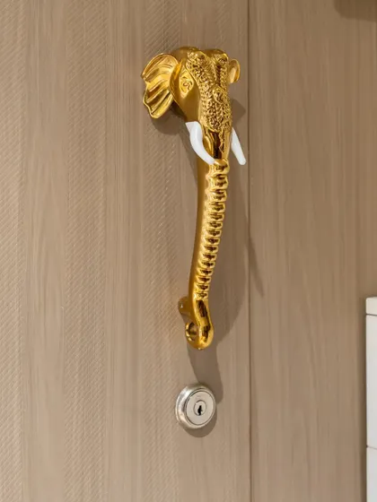 A close-up of a unique, elephant-shaped brass door handle. It's these small, custom details that add a touch of personality and luxury to a home.