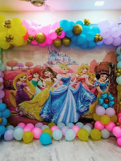 A classic Disney Princess backdrop featuring Cinderella, Belle, and others, framed by a colorful balloon arch.