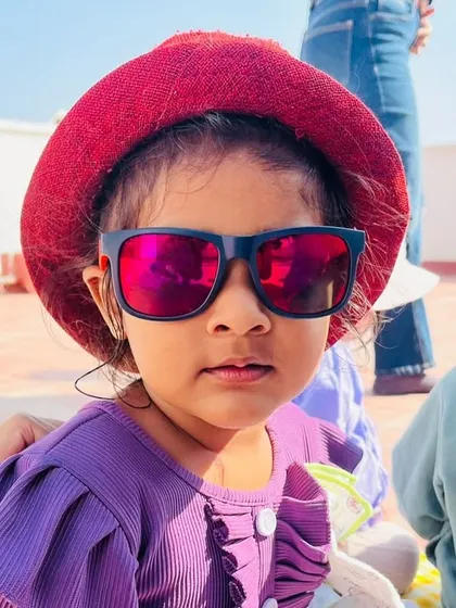 This child is all smiles in her sunglasses and hat, ready for our outdoor lesson on the terrace.