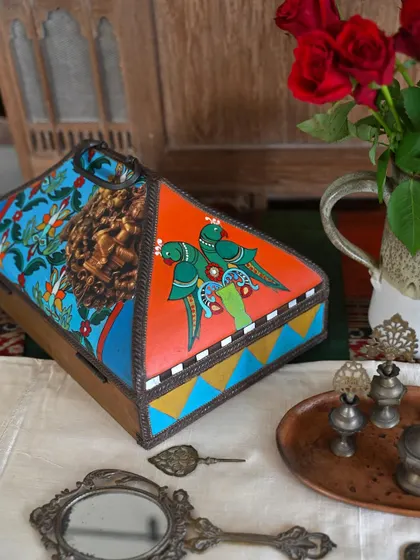 The other side of the box features painted parrots and geometric designs, continuing the theme of vibrant, India-inspired art.