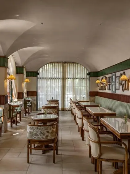 The long view of the cafe shows the rhythmic repetition of arches and the cozy banquette seating that runs along one wall.