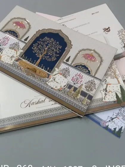 This invitation features a beautiful tree of life motif under a royal arch, with cows illustrated in the foreground. The design is unique and rooted in Indian cultural art.