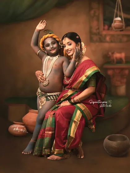A cheerful wave from little Krishna in this beautifully styled studio session. The earthy tones of the backdrop and traditional props like clay pots create an authentic setting, making the portrait feel like a scene from a classic story.