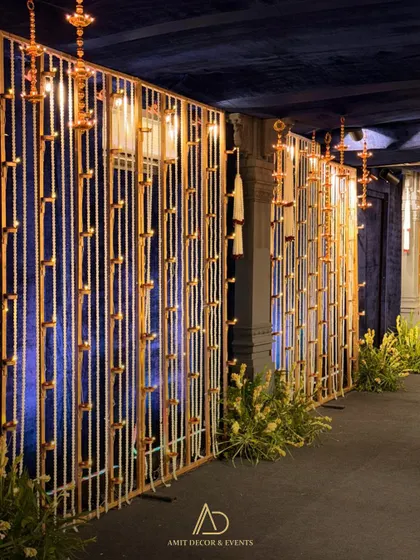 The walkway decor seen from another angle, with the blue backdrop providing a beautiful contrast to the golden glow of the diyas.