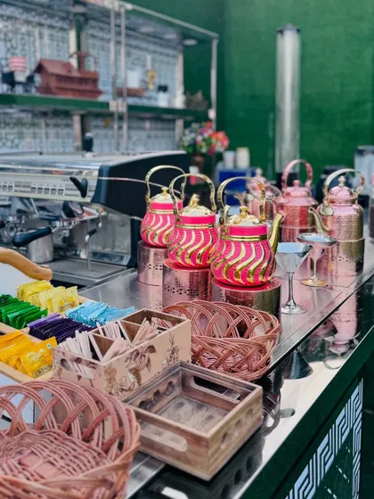 A close-up of the tea and coffee bar, showing a variety of tea bags, syrups, and colorful kettles.
