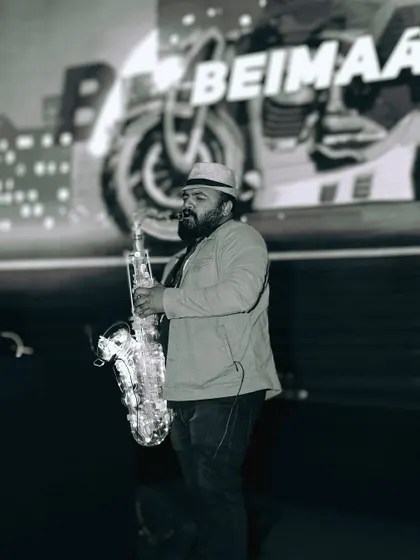 I often collaborate with other talented artists to elevate the experience. Here's a shot of a live saxophonist jamming along with my DJ set at a corporate event, adding a layer of live music to the party.