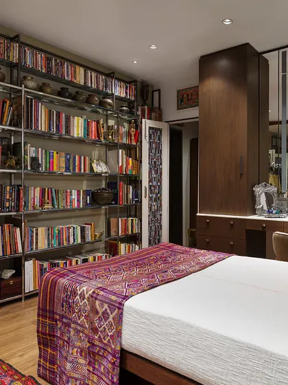 A view of the bedroom in the Courtyard Home, showing the custom dressing table and mirrored wardrobes. The space is highly functional, with ample storage, yet feels personal and curated with its collection of art and objects.