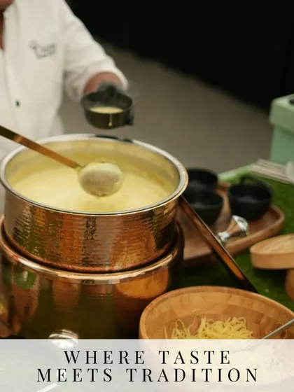Where taste meets tradition. A chef serves a traditional soup or curry from a hammered copper pot, showcasing our use of authentic cookware to enhance the dining experience.