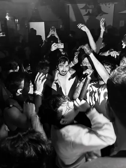 A raw, black and white photo from an intense, intimate boiler-room style party. This captures the underground energy I love.
