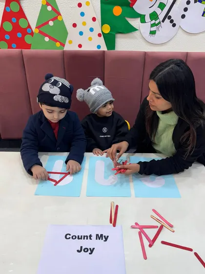 A teacher provides one-on-one guidance during our holiday math game. We adapt our teaching style to each child's needs, celebrating every small step of progress.