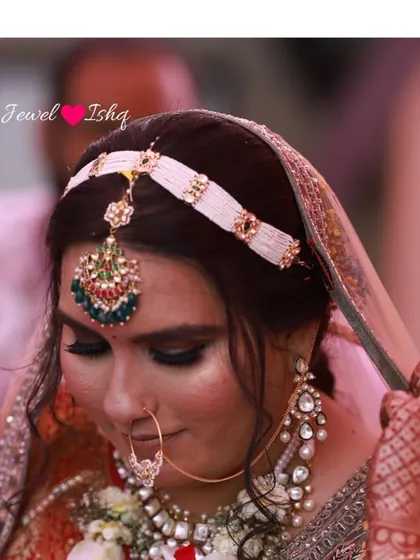 A close-up of our bride Dhruti, showcasing the custom mathapatti and nath we designed for her. The intricate meenakari work adds a pop of color to her look.