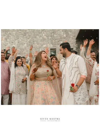 Singing and dancing their way into the celebration. This photo captures the festive spirit and energy of the couple and their guests.