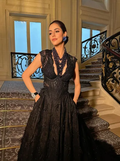 Another angle of this high-fashion look, showcasing the intricate details of the gown and the sophisticated makeup.