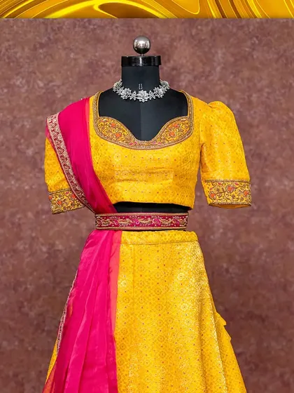 A vibrant yellow half saree for her and a matching brocade kurta for him. This set is perfect for a Haldi ceremony or a festive event.