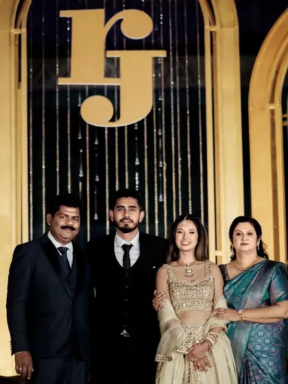 A family portrait in front of the custom reception stage. The large 'RJ' monogram serves as a beautiful and meaningful backdrop for these cherished family photos.