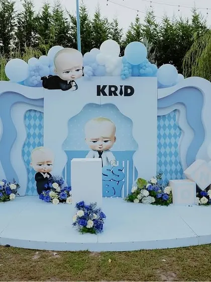 Who's the boss? This "Boss Baby" themed party setup features a multi-layered backdrop in shades of blue and white, complete with character cutouts and a cloud of balloons, perfect for a cool little dude's birthday.