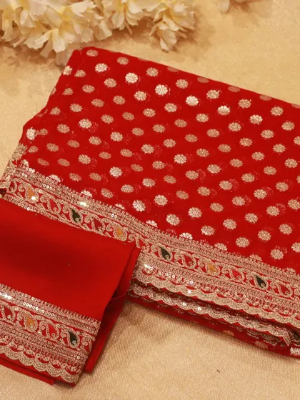 A vibrant red Georgette saree with silver butis and a beautifully embroidered border, inspired by Sabyasachi's designs.