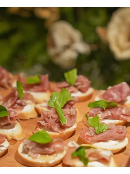 A close-up of delicate prosciutto and basil bruschetta, a classic European canapé that highlights our use of fresh, high-quality ingredients.