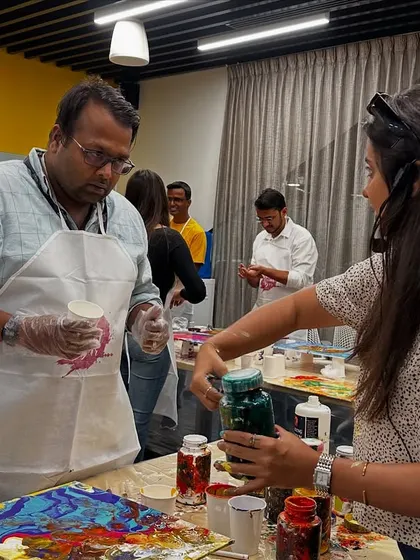 An instructor helping a participant with their paint pour at the GoTo Technologies workshop. We're there every step of the way to ensure a great result.