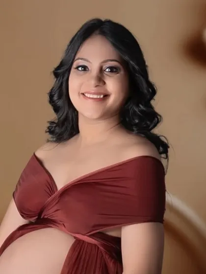 A beautiful close-up portrait showing the joy and anticipation of this mom-to-be. The soft lighting and elegant gown make for a timeless and heartfelt studio maternity photo.