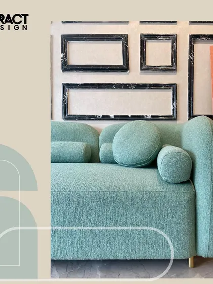 A detail shot of the "Cloud" sofa, highlighting its curved armrest and the rich texture of the moss green bouclé fabric. The simple, elegant lines make it a beautiful centerpiece for a contemporary or modern organic living room.