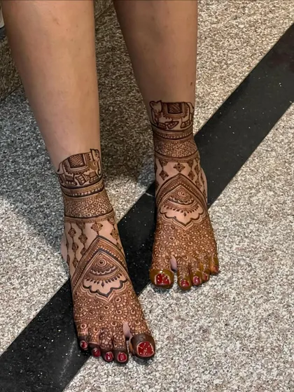 This bridal foot design features elephant motifs inside an architectural frame, symbolizing strength and good fortune.