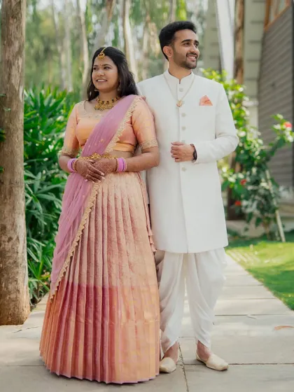 A full-length shot of a couple in their engagement attire, showcasing their coordinated pastel outfits.