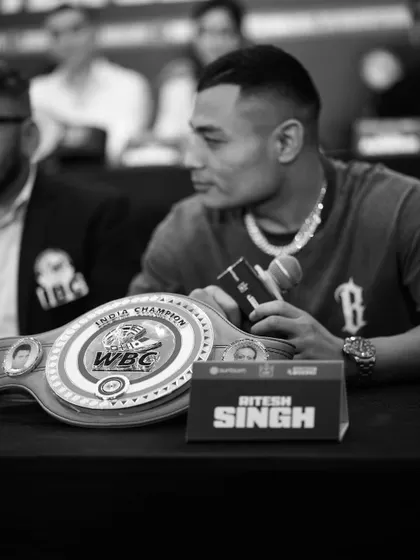 From dreams to the belt. A black and white shot of our WBC India Champion at a press conference, the title he earned in front of him.