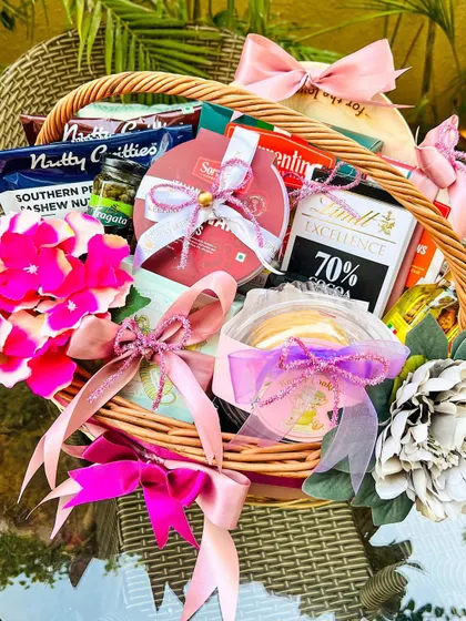 I was thrilled to create this custom birthday hamper for Indian cricketer Bhuvneshwar Kumar. This wicker basket is filled with a curated selection of gourmet treats, including dark chocolate, savory nuts, and other favorites, all elegantly wrapped with pink and lilac ribbons.