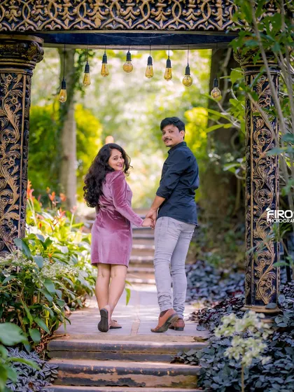 "Follow me to our future." This classic pose on the steps of a wooden walkway feels adventurous and romantic, beautifully captured in their stylish casual outfits.