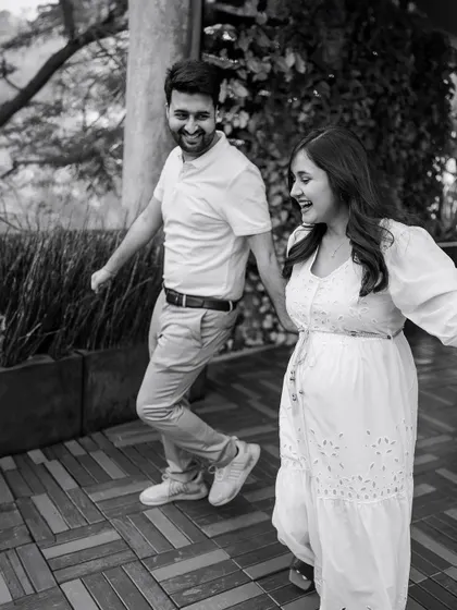 A fun, candid moment of the couple laughing and walking together. This black and white photo captures the pure joy and energy of their relationship.