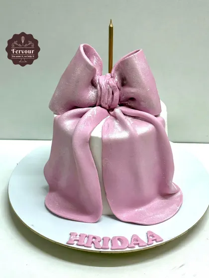 An elegant gift box cake topped with a large, sculpted pink bow. This design is perfect for birthdays, bridal showers, or any occasion that feels like a gift.