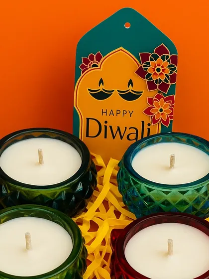 Colorful glass jar candles paired with a "Happy Diwali" tag, making for a simple and cheerful festive gift.