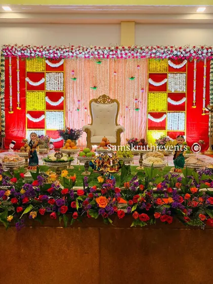 A perfectly designed baby shower stage with a classic red and yellow floral backdrop. This timeless design is always a popular choice for traditional ceremonies.