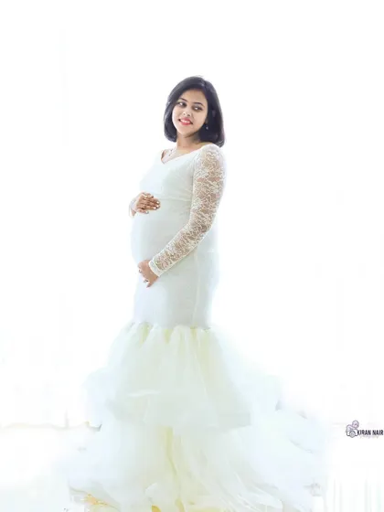 A classic high-key portrait in a white lace mermaid gown. The bright, clean background creates a timeless and angelic look.