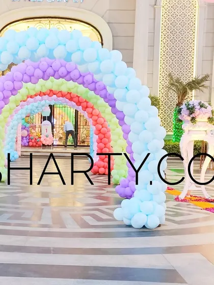 A massive outdoor rainbow balloon arch, creating an unforgettable welcome for guests.